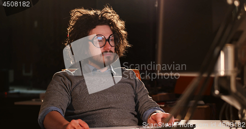 Image of man working on computer in dark office