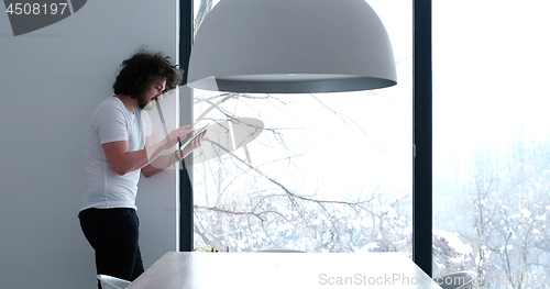 Image of young man using a tablet at home