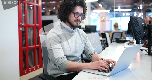 Image of businessman working using a laptop in startup office