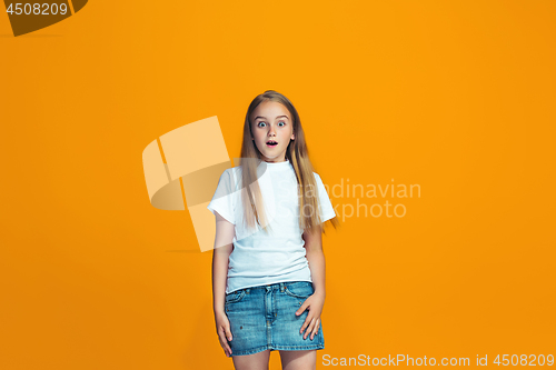 Image of Beautiful teen girl looking suprised isolated on orange