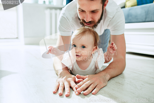 Image of father and his baby daughter at home