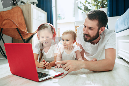 Image of father and his daughters at home