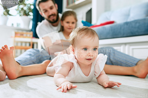 Image of Proud father holding his newborn baby daughter at home