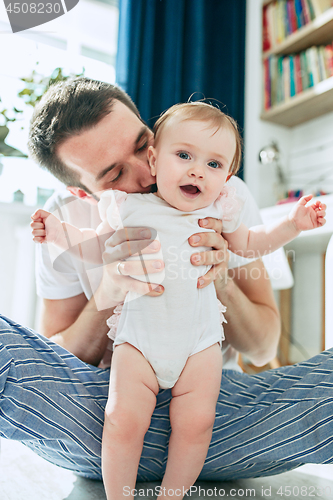 Image of father and his baby daughter at home