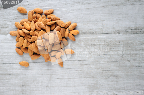 Image of Almonds scattered over white stone board