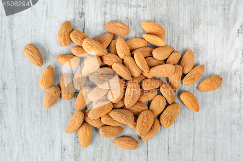 Image of Almonds scattered over white stone board