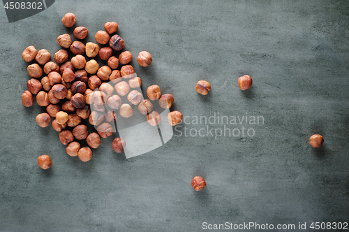 Image of Peeled hazelnuts scattered over stone board