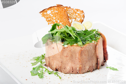 Image of tasty appetizer with sliced veal tongue and riuccola