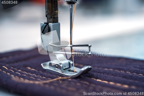 Image of Professional sewing machine close-up. Modern textile industry.