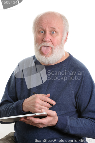 Image of Funny old man with tongue sticking out using tablet computer isolated on white