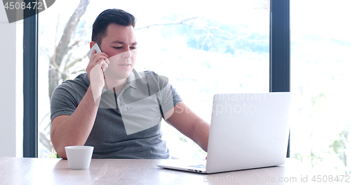 Image of businessman working using a laptop in startup office