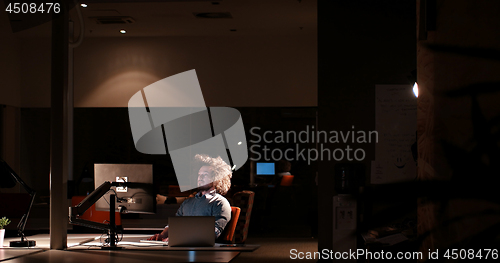 Image of man working on computer in dark office