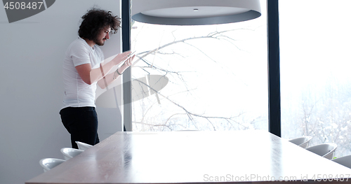 Image of young man using a tablet at home