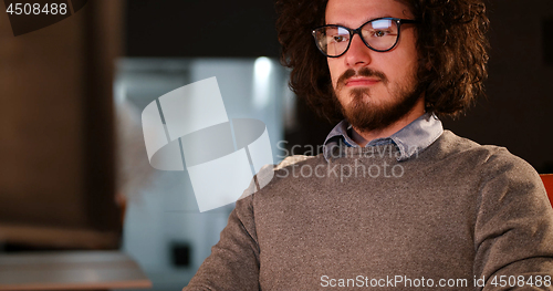 Image of man working on computer in dark office