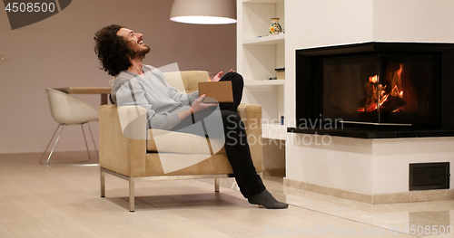 Image of young man at home reading book