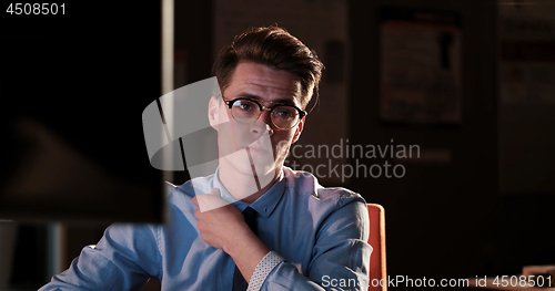 Image of man working on computer in dark office