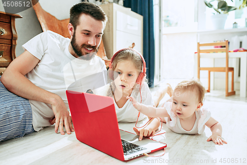 Image of father and his daughters at home