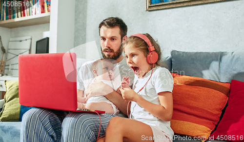 Image of father and his daughters at home