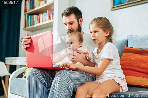 Image of father and his daughters at home