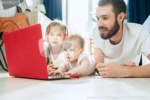 Image of father and his daughters at home