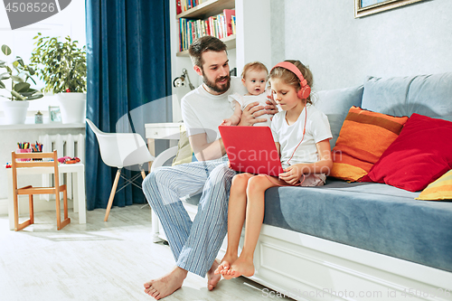 Image of father and his daughters at home