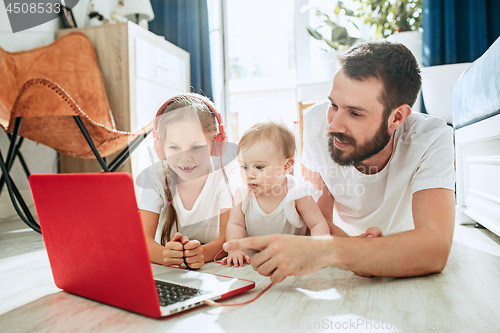 Image of father and his daughters at home