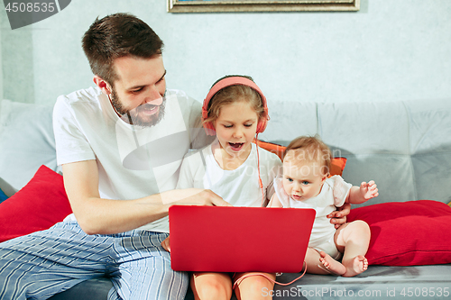 Image of father and his daughters at home