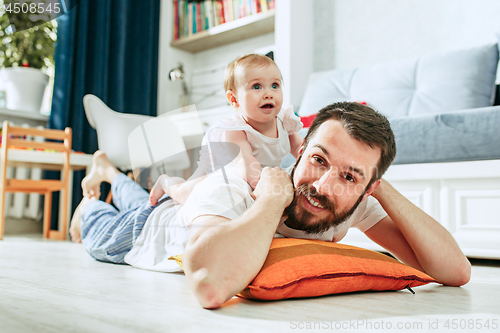 Image of father and his baby daughter at home