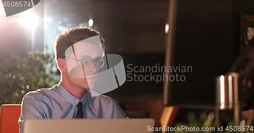 Image of man working on computer in dark office