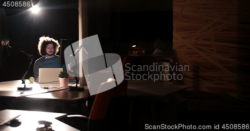 Image of man working on computer in dark office