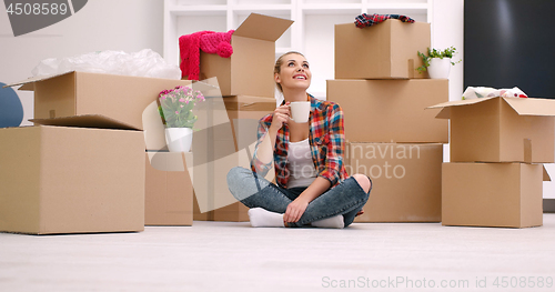 Image of woman with many cardboard boxes sitting on floor