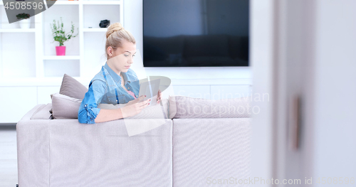 Image of woman on sofa using tablet computer