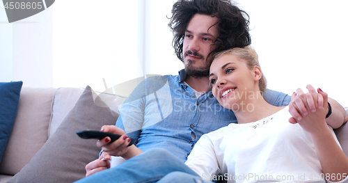 Image of Young couple on the sofa watching television