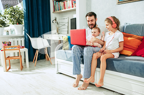 Image of father and his daughters at home