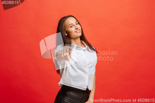 Image of The happy business woman point you and want you, half length closeup portrait on red background.