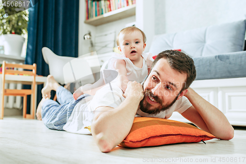 Image of father and his baby daughter at home