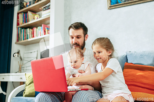 Image of father and his daughters at home