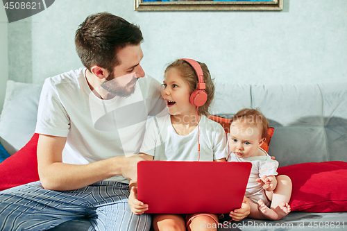 Image of father and his daughters at home