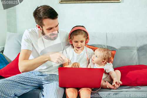 Image of father and his daughters at home