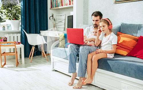 Image of father and his daughters at home