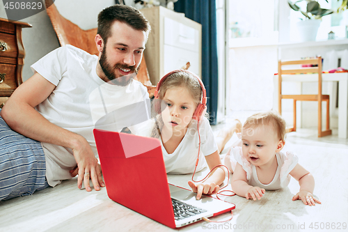 Image of father and his daughters at home