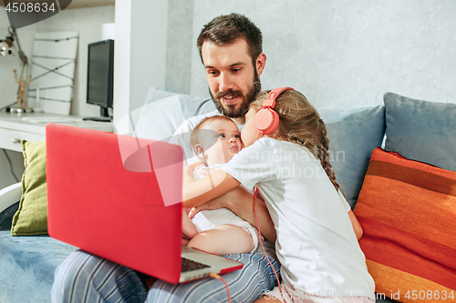 Image of father and his daughters at home