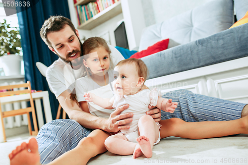 Image of Proud father holding his newborn baby daughter at home