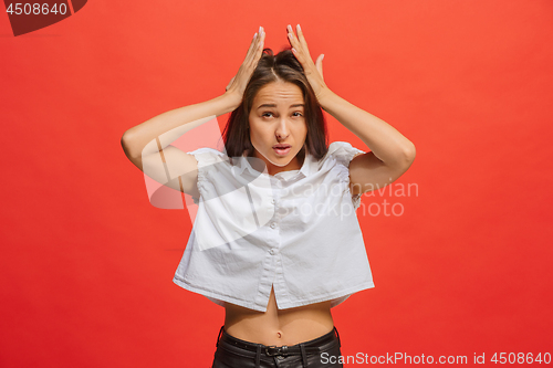 Image of Woman having headache. Isolated over red background.
