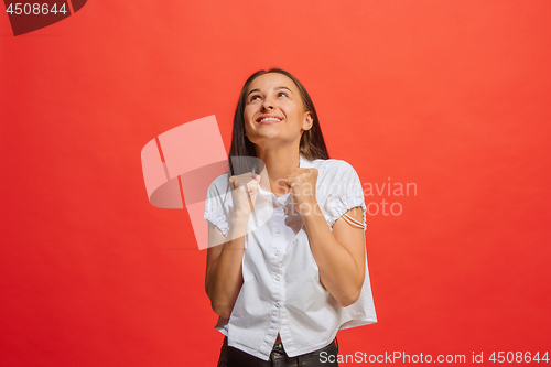 Image of The happy business woman standing and smiling against red background.