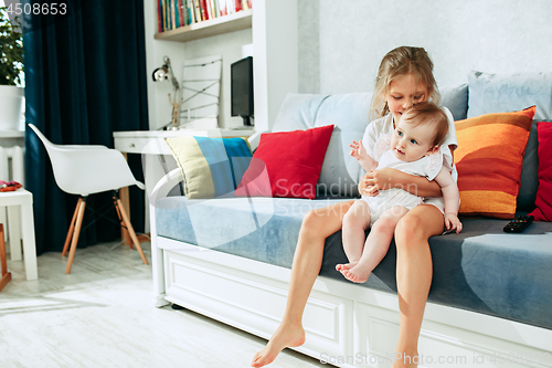 Image of adorable two sisters on bedroom