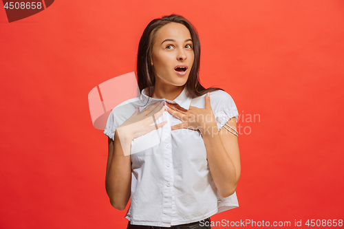 Image of Beautiful woman looking suprised isolated on red