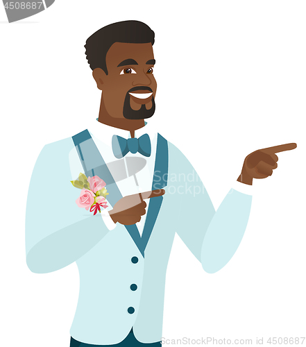 Image of Young african-american groom pointing to the side.