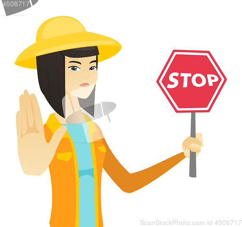 Image of Young asian farmer holding stop road sign.