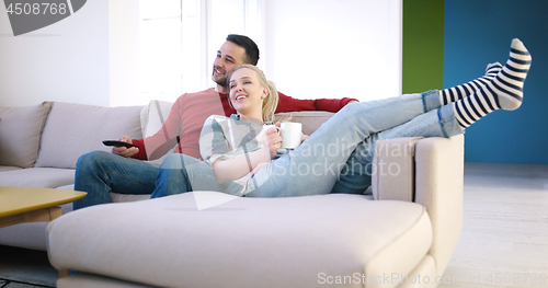 Image of Young couple on the sofa watching television